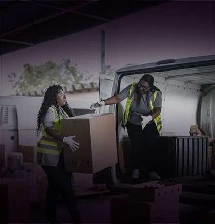 Fundo roxo com uma foto de duas mulheres carregando um veículo de carga.